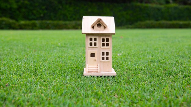 Photo wooden toy house on grass the concept of selling buying renting real estate family home insurance dr