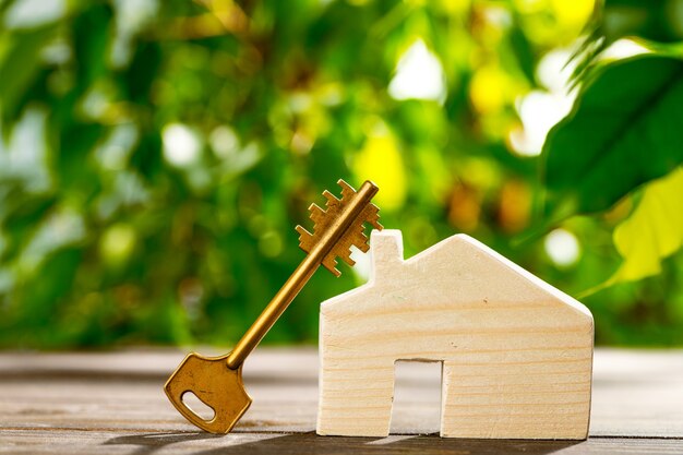 Wooden toy house and house keys close up. Real estate concept