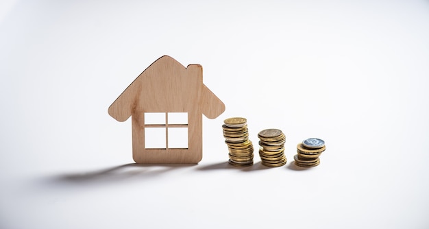 Wooden toy house and money on a white background