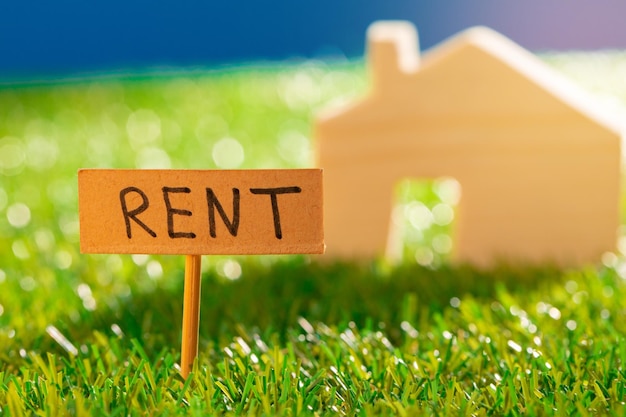 Photo wooden toy house with rent sign on grass