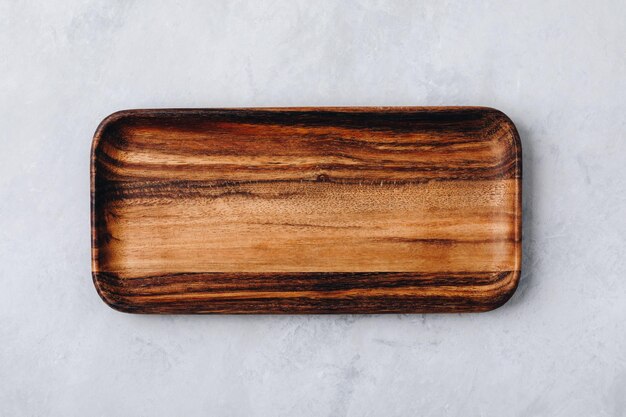 Wooden tray Empty wooden tray plate cutting board on gray stone concrete background top view