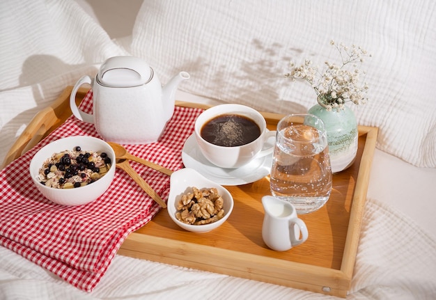 wooden tray with breakfast on a white bed
