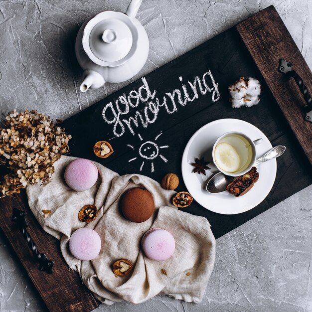 Wooden tray with a cup of tea and cookies