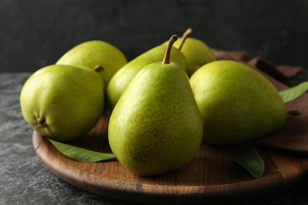 Wooden tray with green pears on black smokey