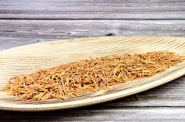 Wooden tray with tari polyphosphate cooked noodles grain.