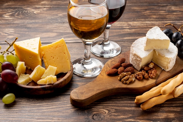 Foto vassoio in legno con varietà di formaggi per degustazione di vini