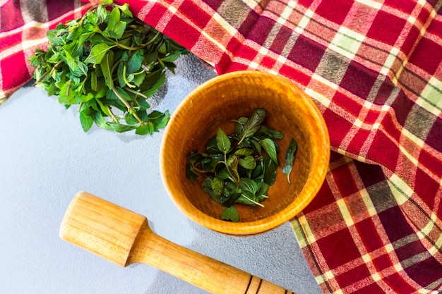 A wooden village mortar for herbs and spices with mint inside