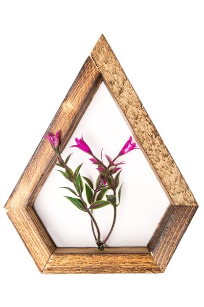 Wooden wall decorative frame in the shape of a pentagon with an artificial flower in the center on a white isolated background