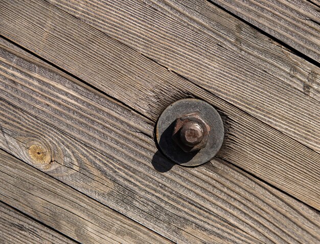 деревянная стена с большим железным болтом в солнечный день, сторона древнего корабля