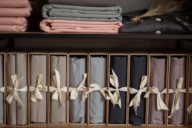 Деревянный шкаф с постельным бельем и одеждой дома или в магазине, концепция дизайна в интерьере