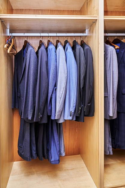 Foto armario in legno con vari abiti nello spogliatoio