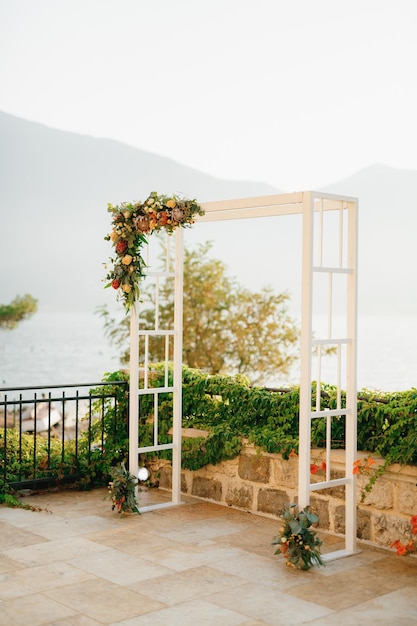 Wooden wedding arch decorated with flowers on the observation deck overlooking the mountains