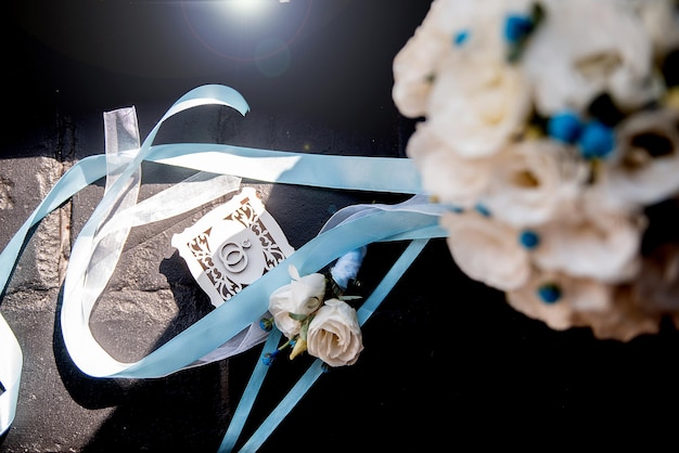 金の指輪と白いちょうど結婚した愛の花束の休日の装飾のための木製の結婚式の箱