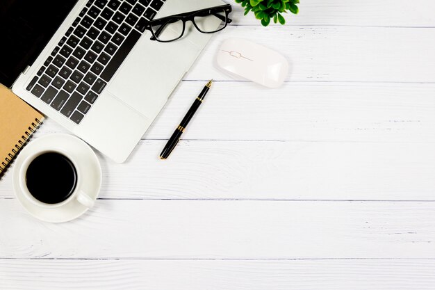 Wooden White desk with blank notebook and other office supplies