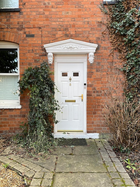 イギリスのれんが造りの家の木製の白い正面玄関