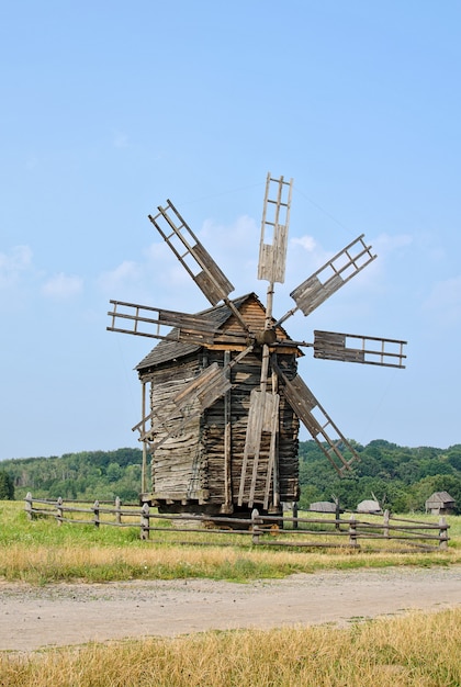 Wooden windmill on the background of the rural landscape