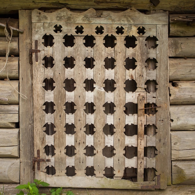 Wooden window with  rough texture surrounded by planks  in old building