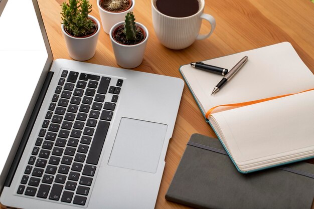 Photo wooden working desk with laptop computer smartphone office supplies and coffee