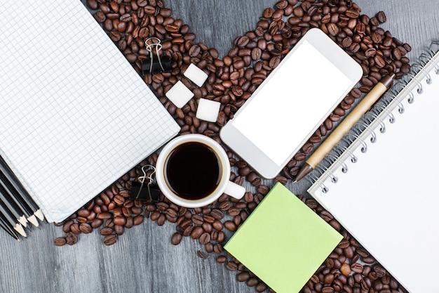 Wooden workspace with smartphone and coffee