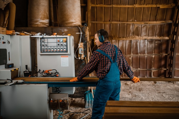 Woodworker works on machine, lumber industry