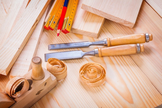 Woodworkers plane chisels wooden meter pencil shavings on wooden boards