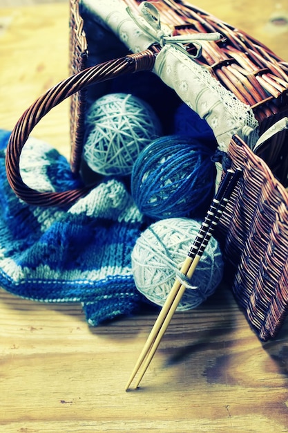 Wool balls and knitting needles on a wood background