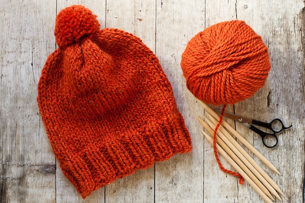 양모 주황색 모자, 뜨개질 바늘과 실