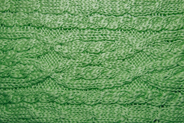 Fine di struttura del maglione o della sciarpa della lana su. fondo in jersey lavorato a maglia con motivo a rilievo