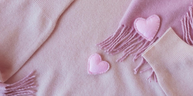 Woolen cute hearts decorate pink cashmere clothes top view Valentines day concept warm cozy