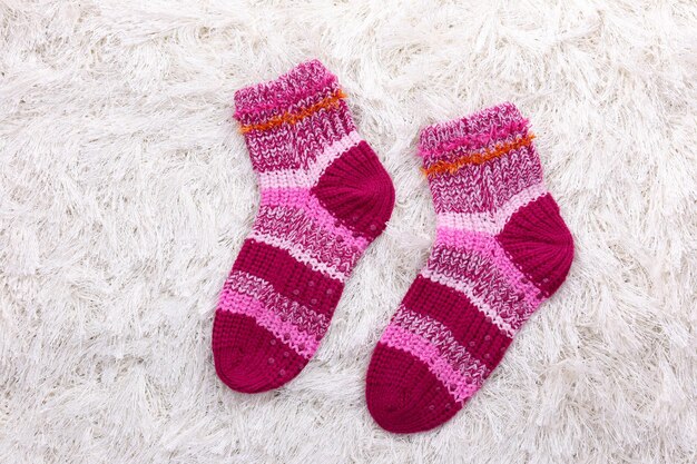Woolen socks on color background