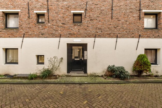 Woongebouw met meerdere verdiepingen met ramen van verschillende formaten en een betegeld pad voor het huis