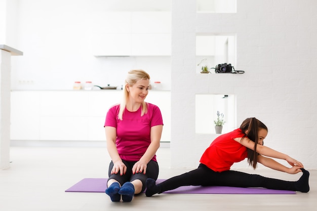 Woonkamer fitness workout meisje doet oefeningen thuis. Jonge vrouw die spieren traint, gezonde levensstijl zonder naar de sportschool te gaan.