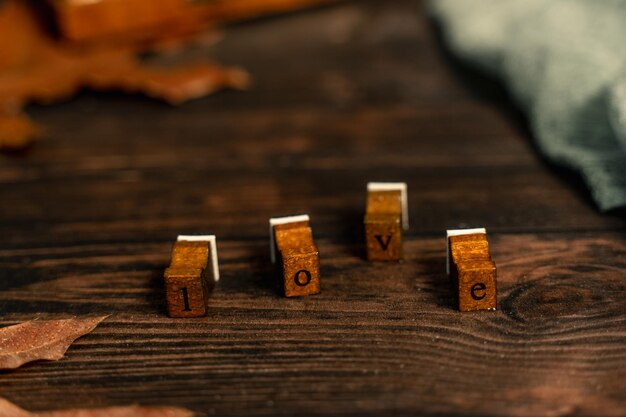woord liefde gemaakt van houten stempels op een houten donkere tafel met onscherpe achtergrond