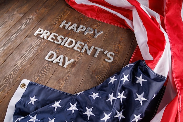 Foto woorden gelukkige presidentendag gelegd met echte letters op een houten bord in de buurt van de amerikaanse vlag