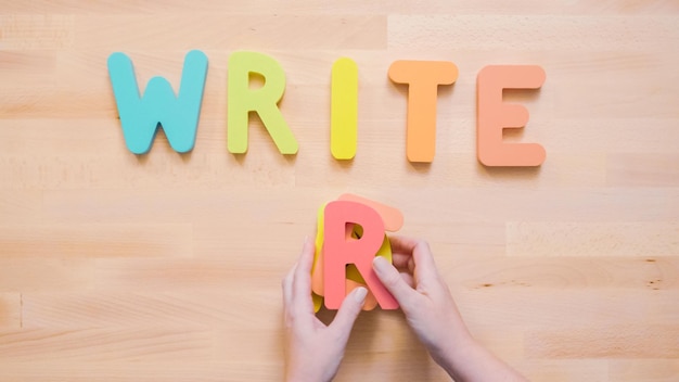 Woorden lezen en schrijven van veelkleurige houten letters op houten tafel.