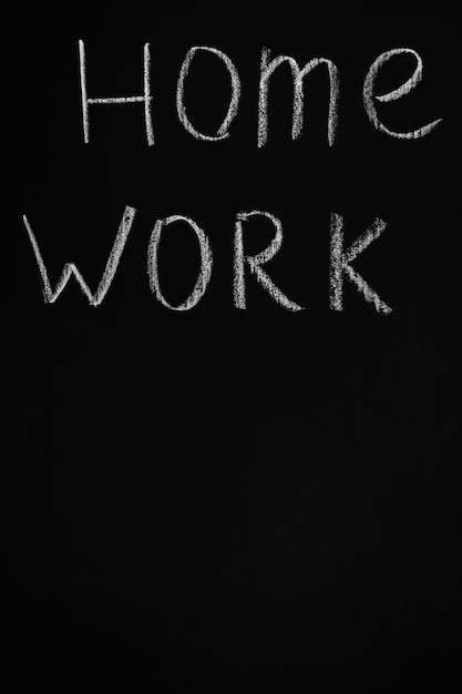Woorden thuiswerk op zwart bord met kopie ruimte Thuiswerk concept Krijtwoorden School schoolbord