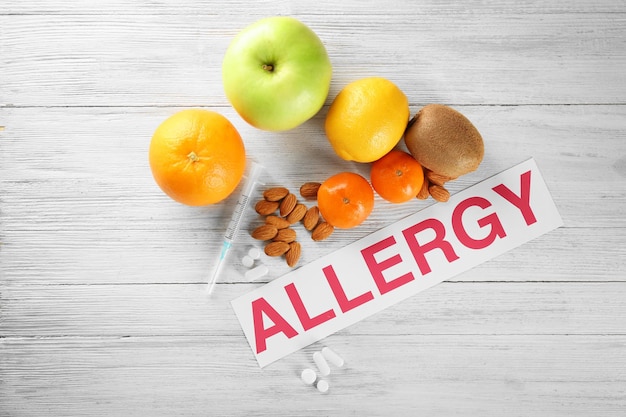 Photo word allergy food and syringe on wooden background