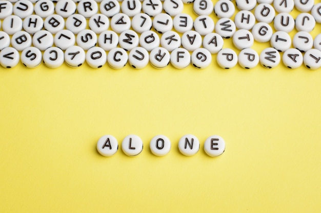 Photo the word alone made of white plastic blocks