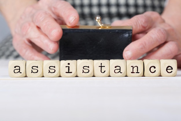 Word ASSISTANCE composed of  wooden dices.. Closeup