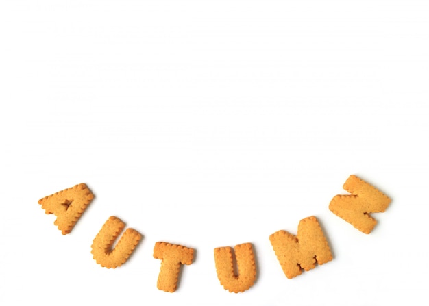 The word AUTUMN spelled with alphabet shaped biscuits on white, 