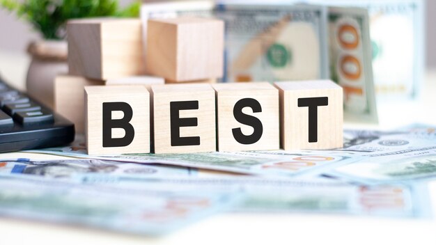 The word best on wood cubes, banknotes and calculator on the background, business and finance concept