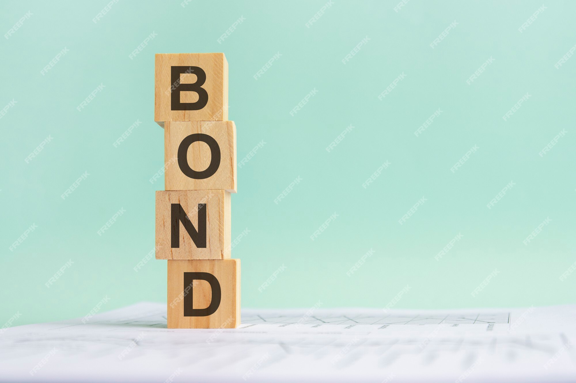 Premium Photo | Word bond with wood building blocks, light blue background. document with numbers on background, business concept. space for text in right. front view. Premium Photo | Word bond with wood building blocks, light blue background. document with numbers on background, business concept. space for text in right. front view.