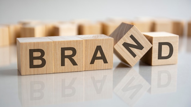 Word BRAND on wooden cubes, gray background