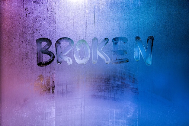 Photo the word broken handwritten on wet window glass