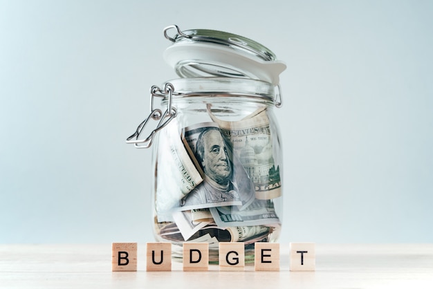 Photo word budget and dollar bills in glass jar