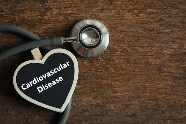 Word cardiovascular disease on heartshaped board with a stethoscope on wooden background Medicine and cardiology concept