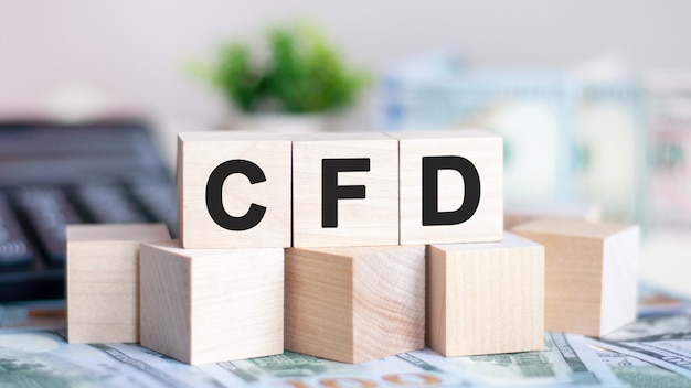 The word CFD on wood cubes, banknotes and calculator on the surface.