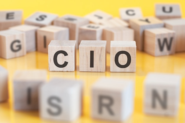 Слово cio написано на деревянной конструкции из кубиков. Блоки на ярком фоне. финансовая концепция. Выборочный фокус