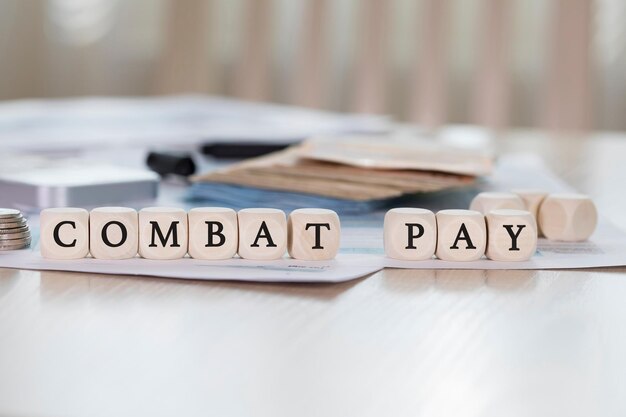 Word COMBAT PAY is composed of wooden letters. Closeup