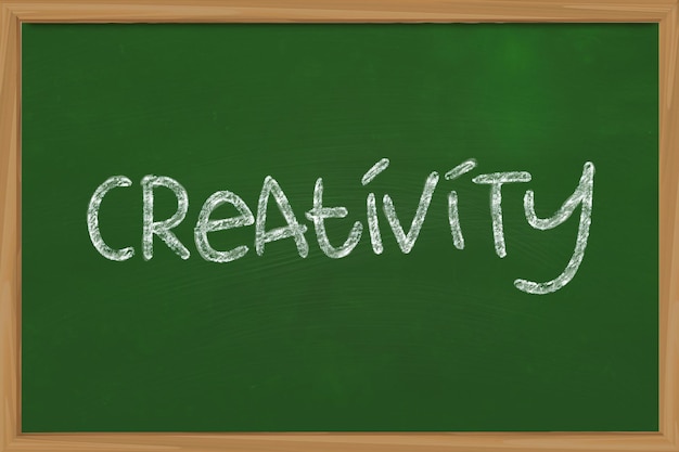 The word Creativity written with chalk on green chalkboard